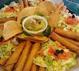 A catering platter of flautas with guacamole