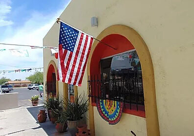 The Espo's storefront with an American flag over the arched entry