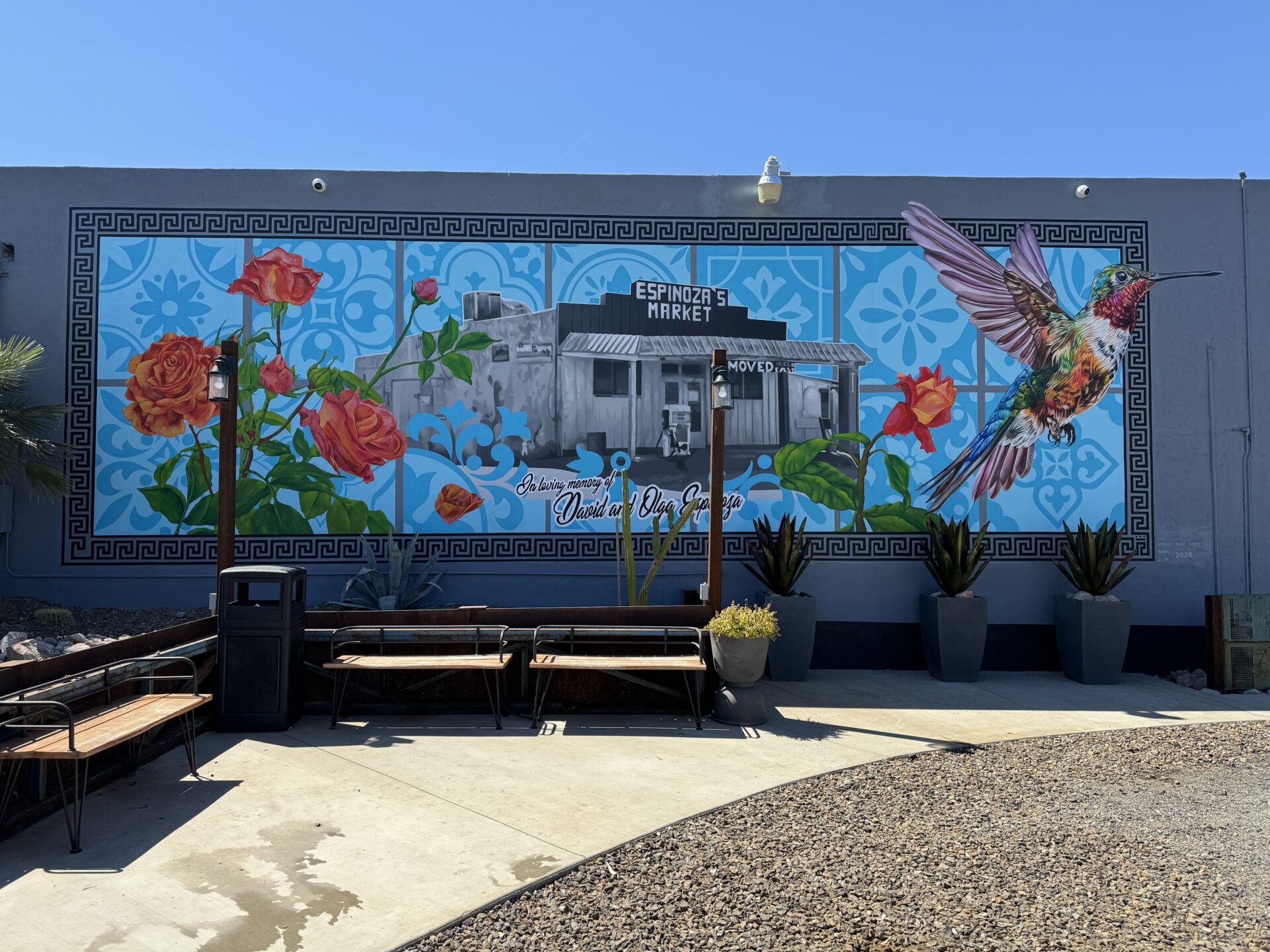 A mural of flowers and birds on the side of a building.